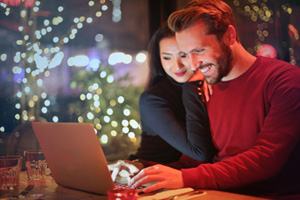 A photo of a man and woman looking at a laptop